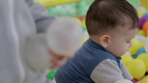 kids brothers baby preschooler boys playing in ball pit pool colorful soft plastic toys play center