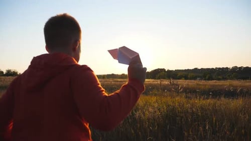 Follow to Cute Little Child Jogging with a Paper Airplane Through Meadow