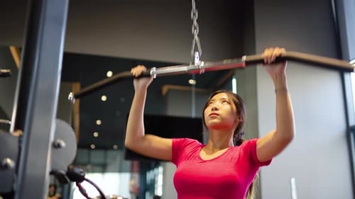 Joven asiática hace ejercicios de acondicionamiento físico en el gimnasio, máquina desplegable, atención médica, ejercicio firme, saludable