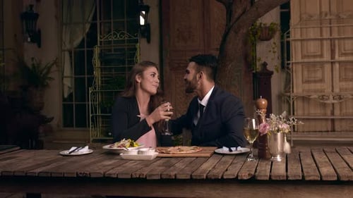 Couple Enjoying Romantic Dinner at Outdoor Cafe
