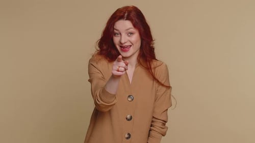 Woman Pointing to Camera and Looking with Playful Happy Expression Making Choice Showing Direction