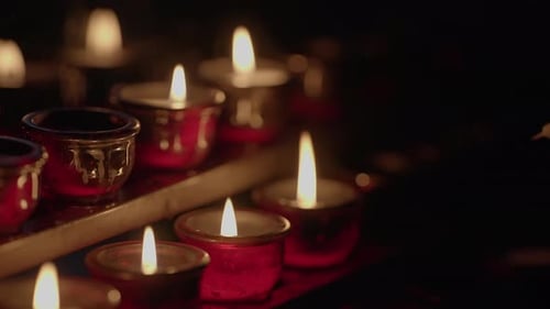 Burning Candles in a Dark Setting are Lit