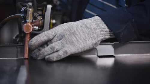 A Factory Worker Uses Spot Welding to Join Steel Parts
