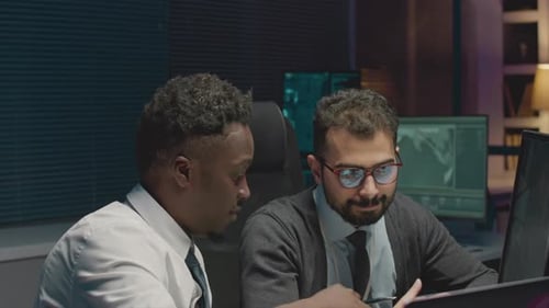 Cybersecurity Engineers Coworking at Night Office