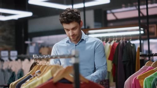 Man Client Walking Clothes Rows in Boutique Closeup Satisfied Customer Smiling