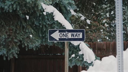 Placa de rua unidirecional coberta de neve