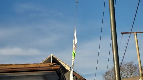 Long White Plastic Streamer Hanging from Wire Outdoors