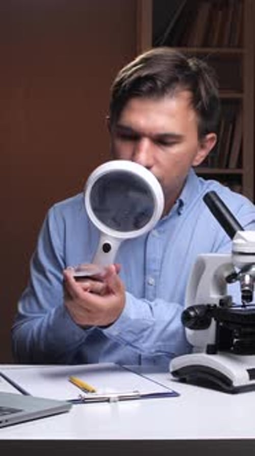 Young Adult Examining Object with Magnifying Glass