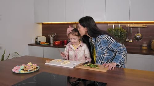 Girl and Woman Cutting Fruit Together in Kitchen