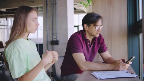 Young Adult and Adult Working Together at Office