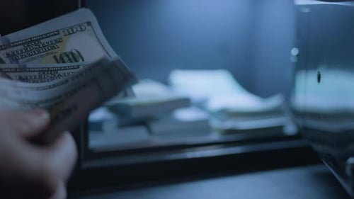 Um empresário está contando dinheiro com um cofre em segundo plano