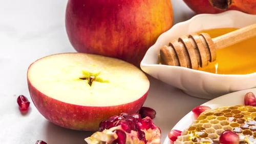 Fondo de fiesta de Año Nuevo judío de Rosh Hashaná con miel, granada y manzanas sobre mármol blanco