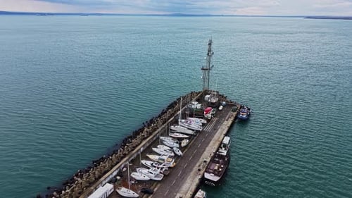 Boote legten am Pier an, über dem ruhigem Wasser und bewölktem Himmel
