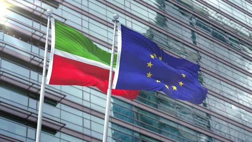 Realistic European Union and Second Flag Waving in Front of Modern Building