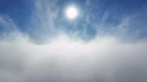 Sunlight over Fluffy White Clouds in Blue Sky