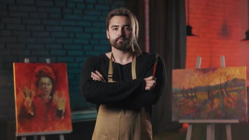 Confident Artist with Brush in Hands Posing in Art Space