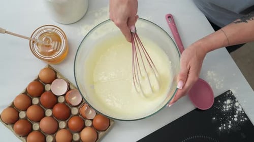 Person, die einen cremigen Gebäckmehlteig umrührt, um ein Dessert zuzubereiten. Zenital-Schuss