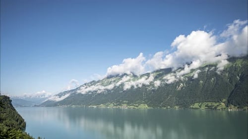 Zeitraffer weißer, flauschiger Wolken an einem alpinen Seeufer. Die Wolken bilden und ändern sich schnell auf der