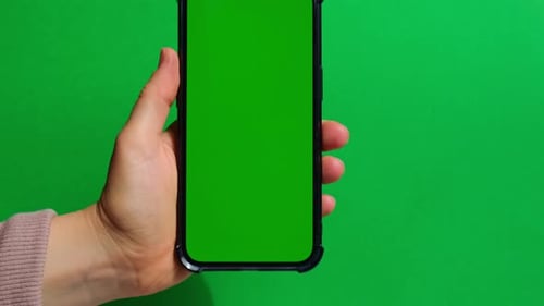 Hands Holding Cell Phone with Green Screen on Green Background
