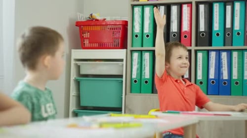 Young Boys Attending Class and Raising Hands