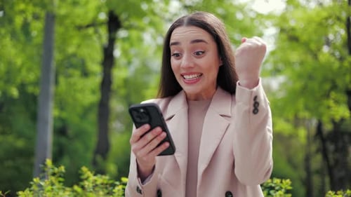 Woman Reacts with Joy to Something on Her Phone