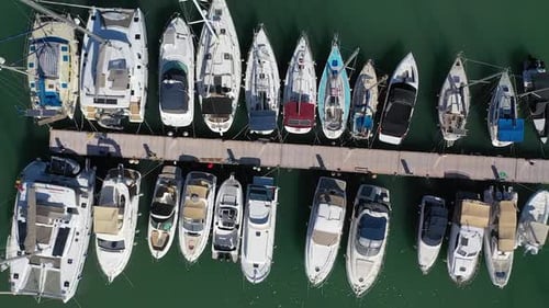 Harbor with moored sailing boats to the pier at Latchi port, aerial rise up view