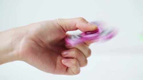 Juega a mano con un juguete giratorio rosa brillante, un moderno dispositivo de relajación