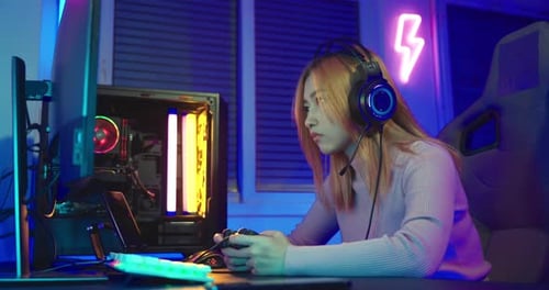 Excited Young Woman Gaming at Night