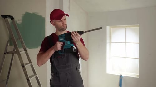 Construction Worker Evaluating Rotary Hammer Drill During Home Renovation