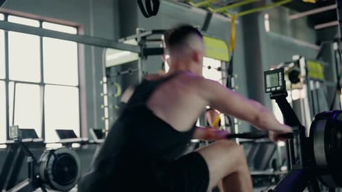 Man Using Rowing Machine at the Gym