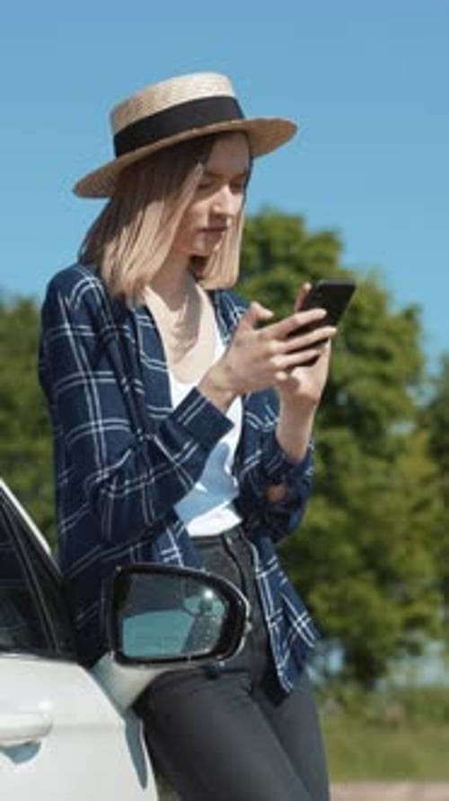 Woman Leans on Car, Using Mobile Phone on Road