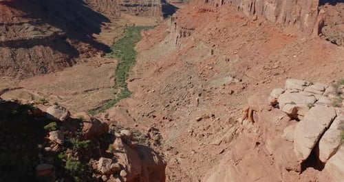 Man Walks On Tightrope Over Red Rock Canyon in Moab, USA