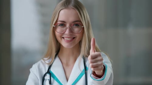 Portrait Caucasian Doctor Showing Thumb Up Like Gesture Smiling in Clinic Looking at Camera Happy