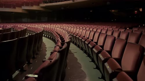 Empty Theater With Comfortable Red Chairs Cinema Seats in Dark Theatre Wide Shot