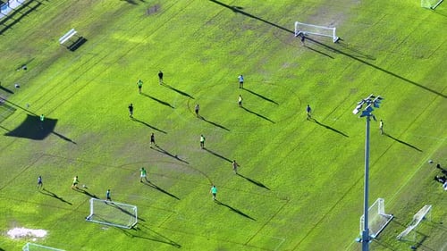 Aerial View of Young Adult Amateur Sportsmen Playing Soccer on Grass Covered Sports Stadium