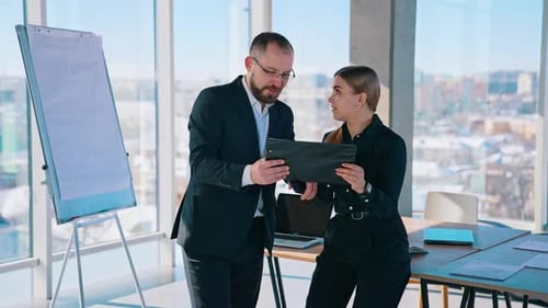 Colleagues Viewing Tablet in Bright Modern Office