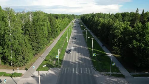 Vista aérea del tráfico de la ciudad en la carretera que atraviesa una zona boscosa en un día de verano