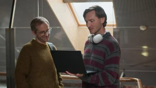 Middle-Aged Developers Discussing Software on Laptop in Office