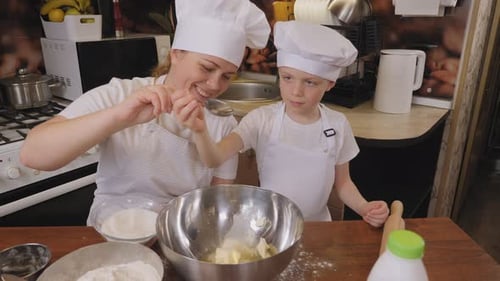 A Boy Learns How to Make a Cake with His Mother He Pours Sugar Into a Bowl