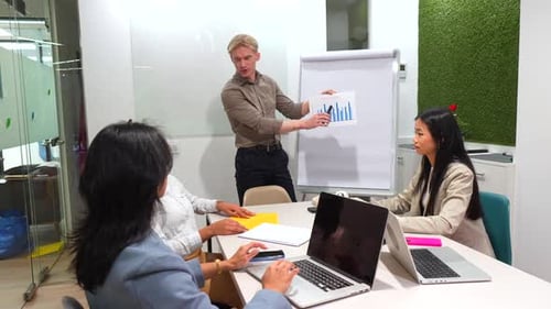 Business Team Analyzing Charts During Coworking Office Meeting