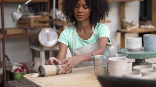 Young women is making earthenware at workshop.