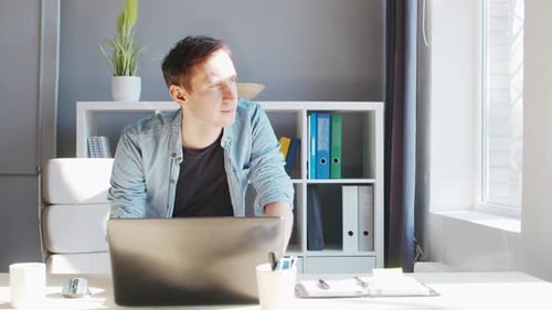 Young Male Entrepreneur Works at Home Office at the Computer Workplace of Freelancer or Student