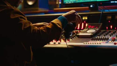 Man Using Headphones at a Sound Mixing Board
