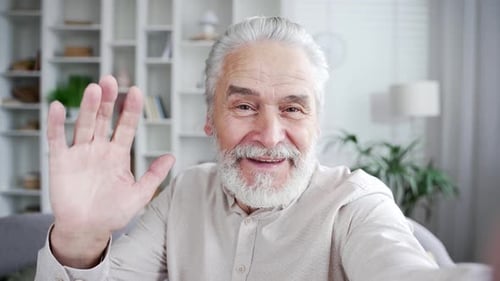 POV Elderly senior gray haired man talking on a video call taking a selfie using a smartphone