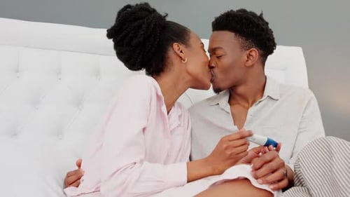 Joyful Couple Celebrating Positive Pregnancy Test at Home