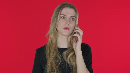 Young Woman Talking on Smartphone on Red Background