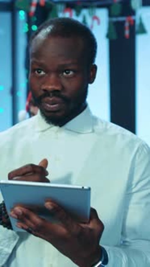 Man with Tablet at Festive Party Cheers Friends