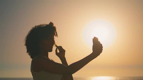 Woman Taking Selfie on Beach at Sunset