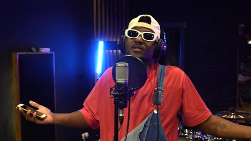 Young african american artist recording vocals in music studio