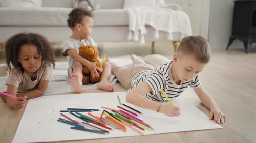 Three Children Drawing Together at Home